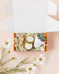 Load image into Gallery viewer, a box with some flowers and a candle in it