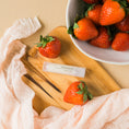 Load image into Gallery viewer, a wooden cutting board topped with strawberries next to a bowl of strawberries