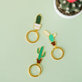 Load image into Gallery viewer, a pair of gold - plated metal cactus and cactus keychains