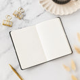 Load image into Gallery viewer, an open notebook sitting on top of a table next to a pen