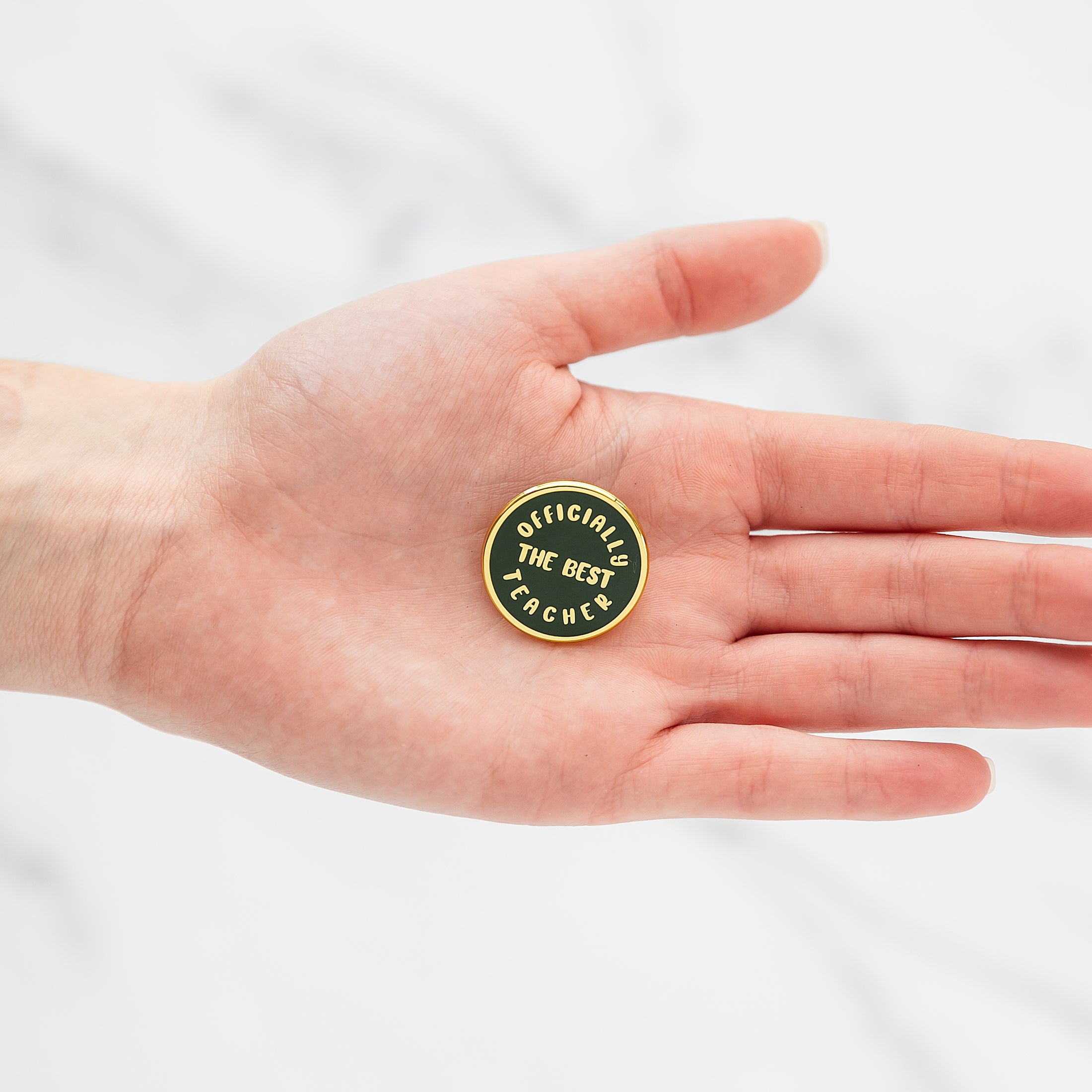 a person's hand holding a green and yellow badge