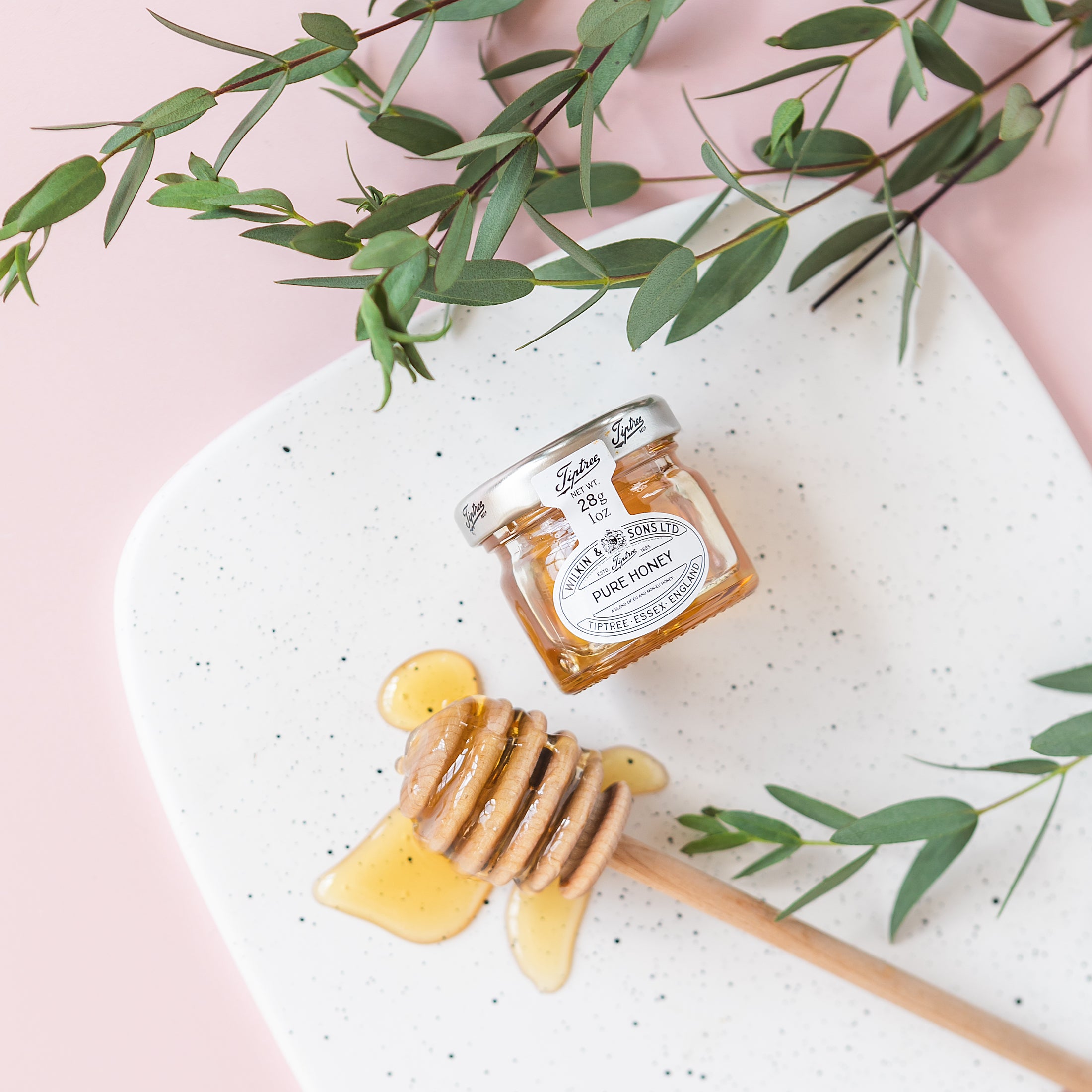 a jar of honey sitting on top of a white plate