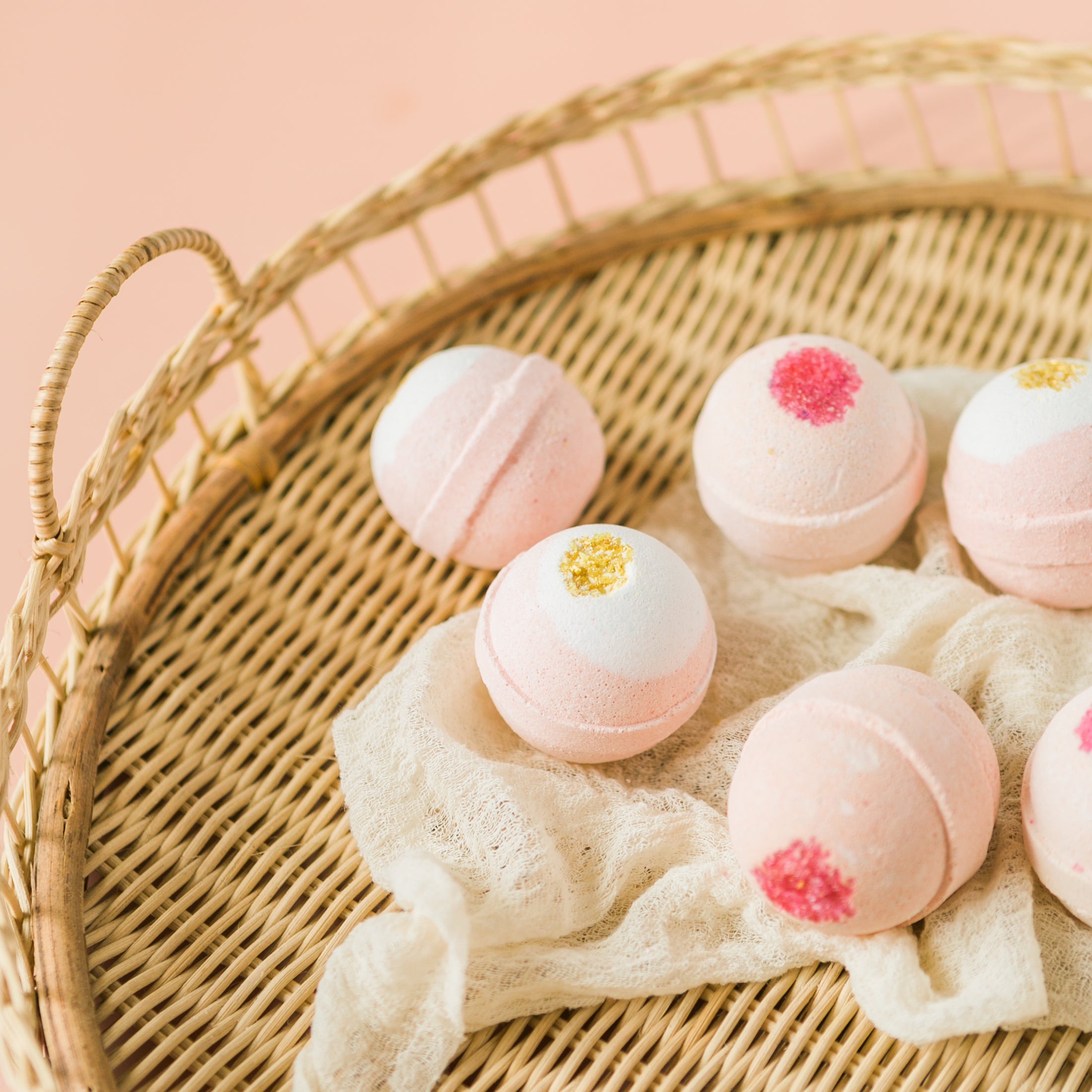a basket filled with pink and white bath bombs