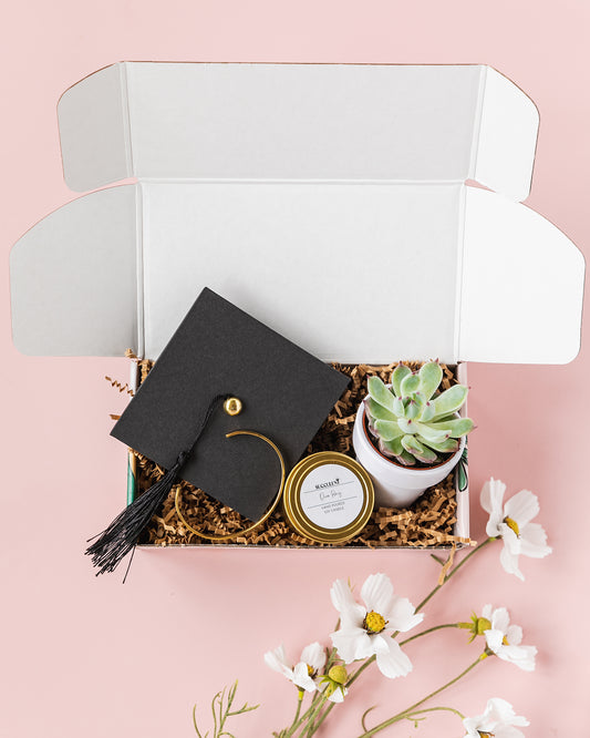 a graduation cap and a plant in a box