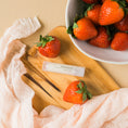 Load image into Gallery viewer, a wooden cutting board topped with strawberries next to a bowl of strawberries
