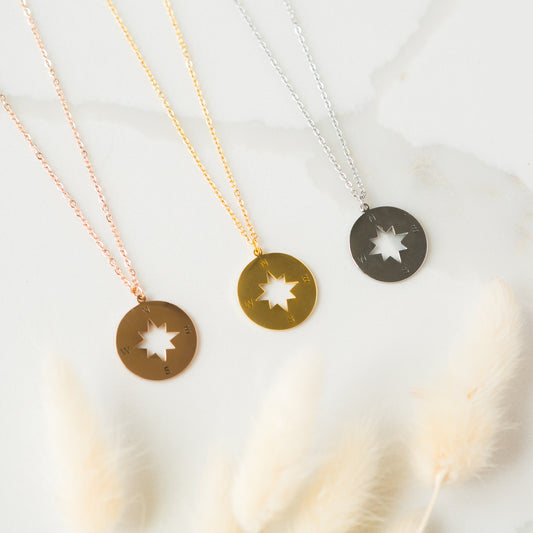 three necklaces on a white surface with feathers