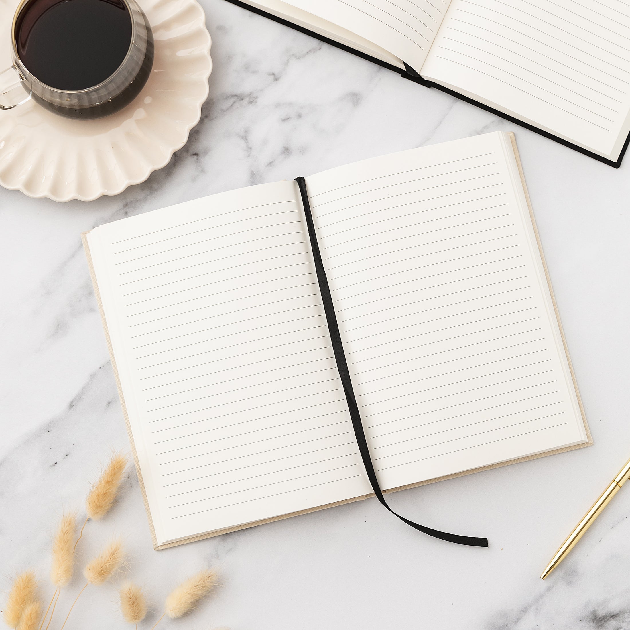 an open notebook sitting on top of a table next to a cup of coffee