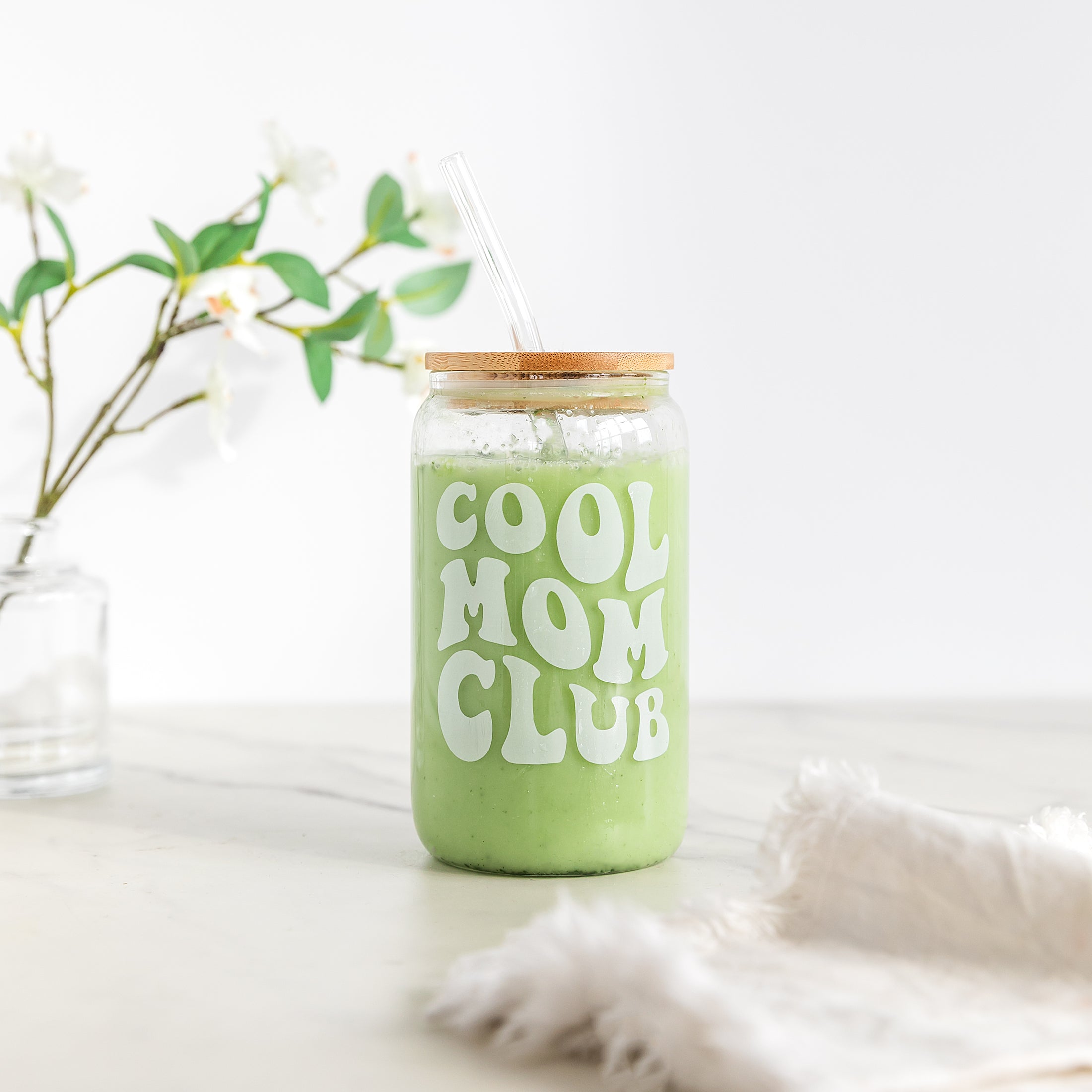 a green mason jar with a straw in it