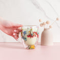 Load image into Gallery viewer, a person is holding a glass cup with flowers on it
