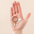 Load image into Gallery viewer, a hand holding a pair of scissors and a keychain

