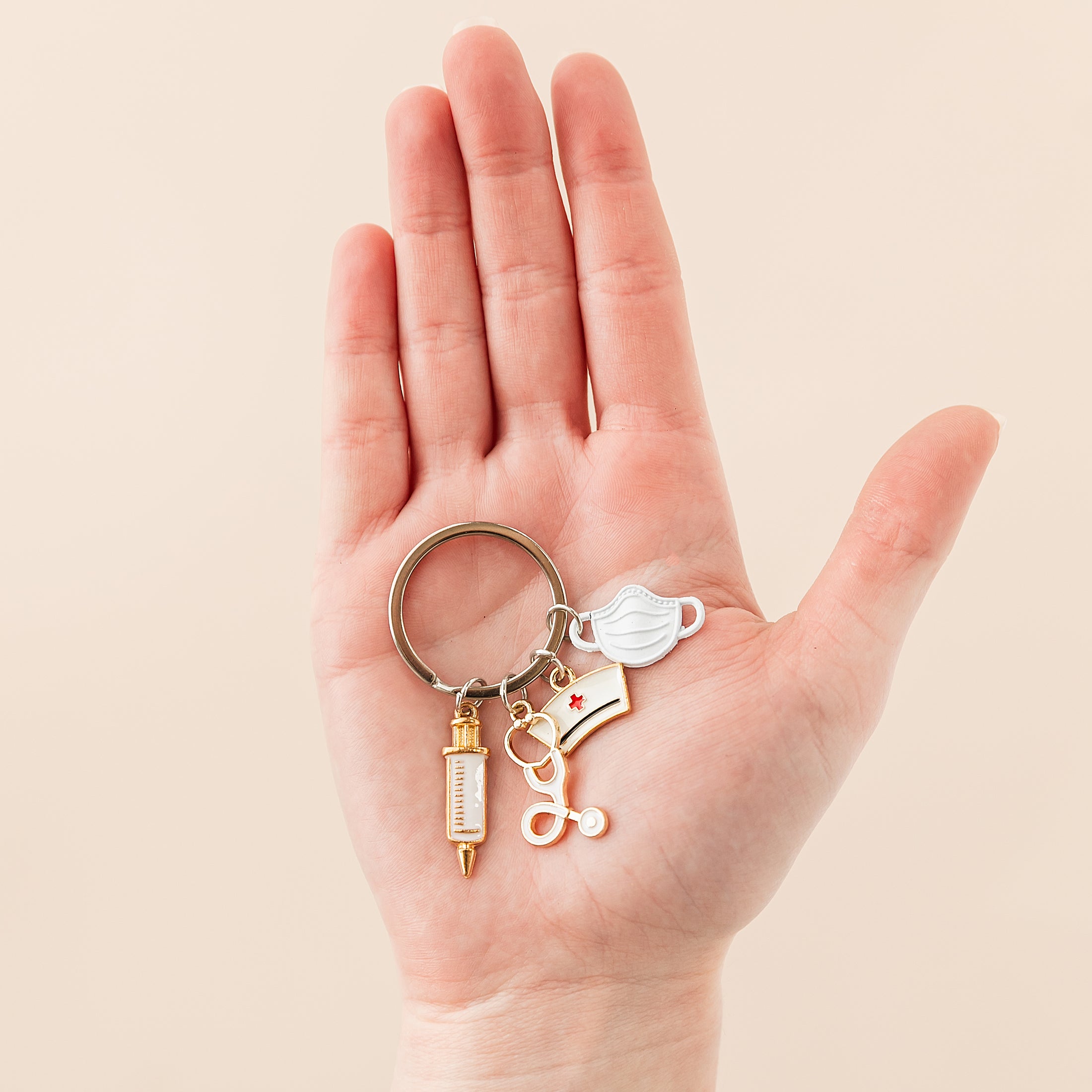 a hand holding a pair of scissors and a keychain