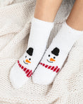 Load image into Gallery viewer, a pair of snowman socks sitting on top of a white blanket
