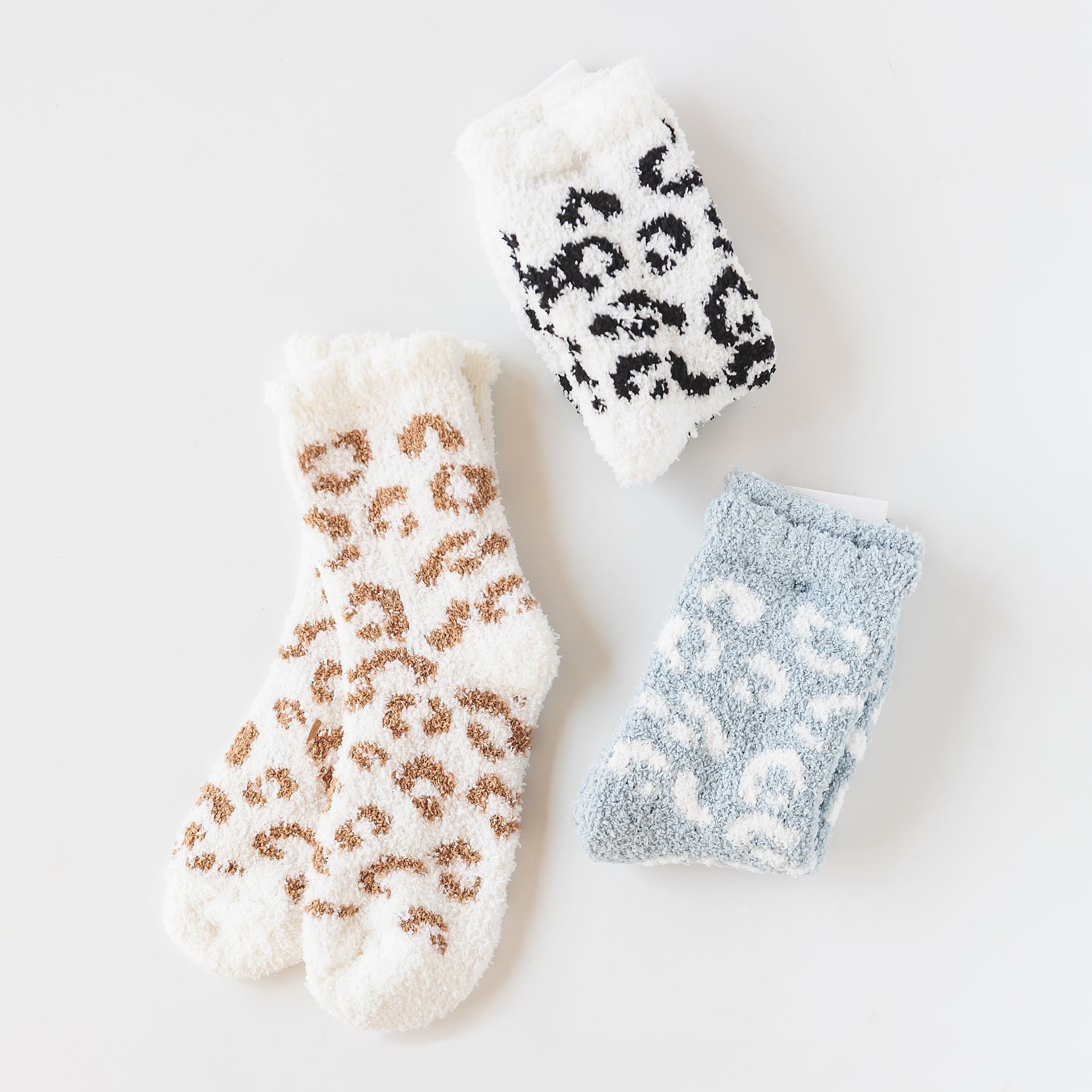 three pairs of animal print socks on a white surface