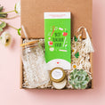 Load image into Gallery viewer, a gift box with a green book, a jar, a candle, and a
